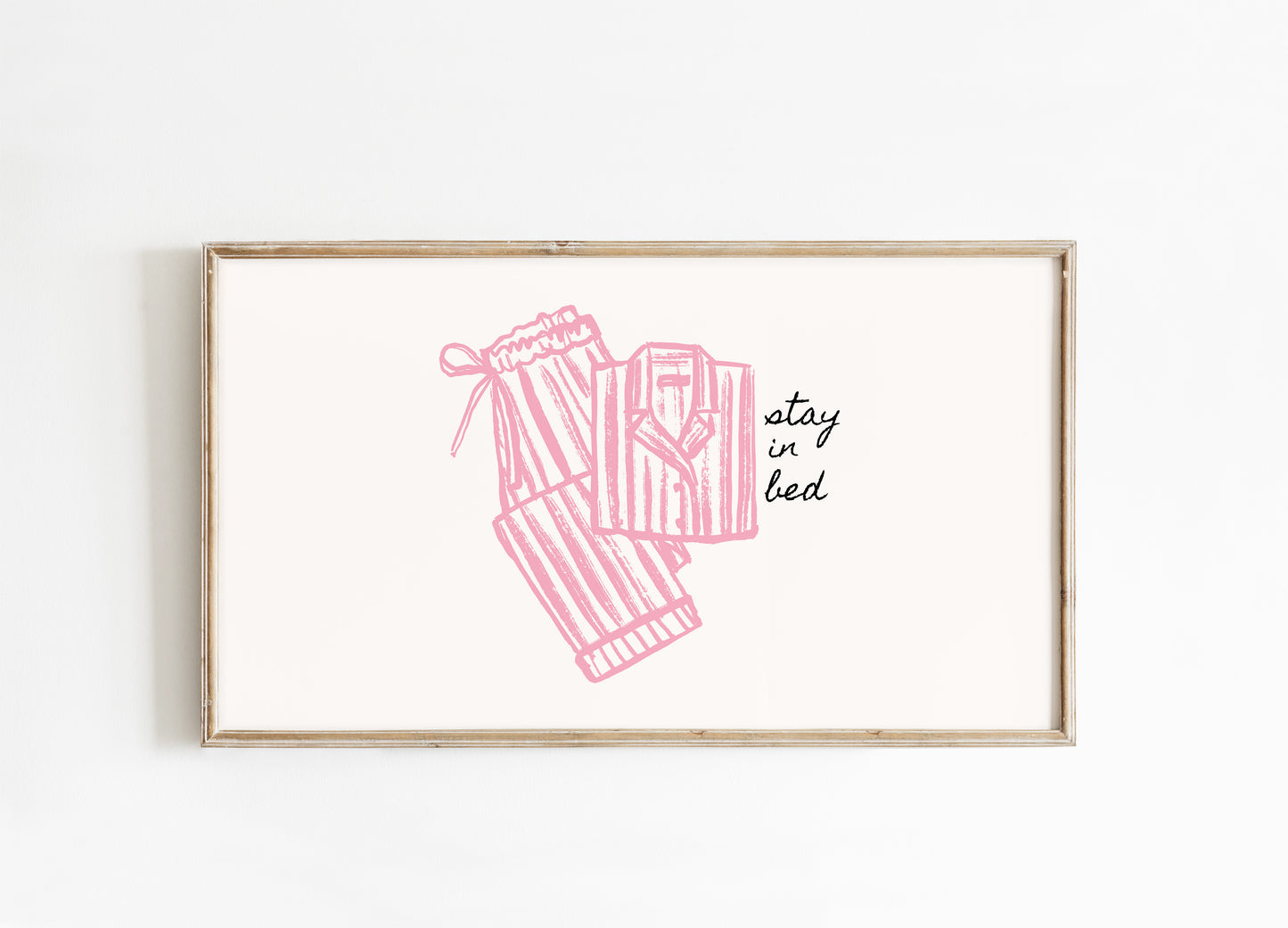 Framed artwork with pink pajama illustration and 'stay in bed' text on a white background