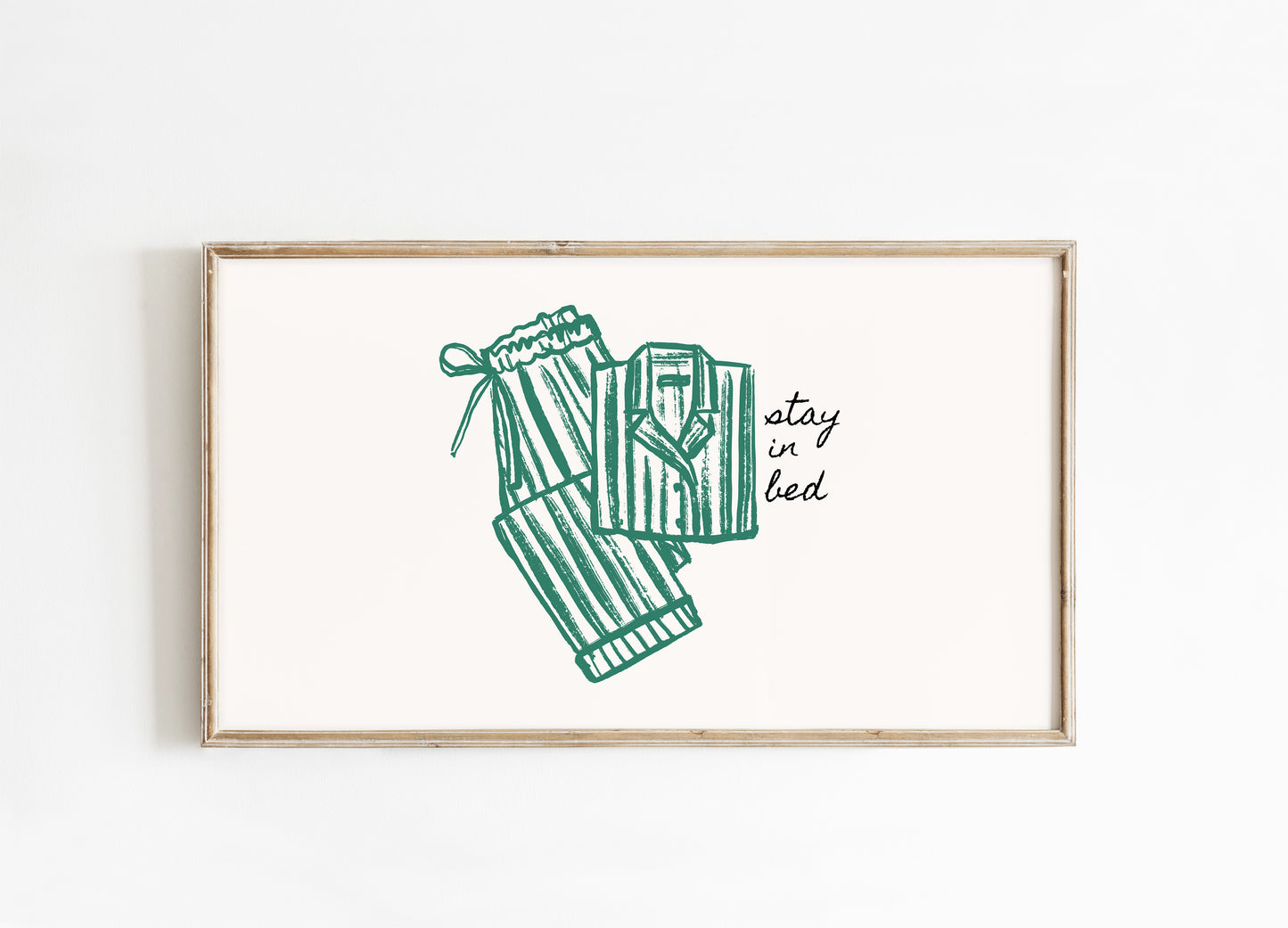 Framed artwork with green pajamas illustration and 'stay in bed' text on a white background
