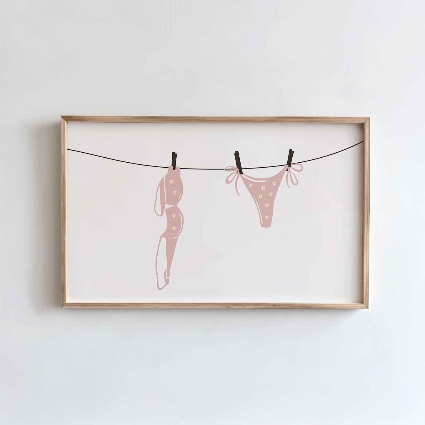 Framed artwork of pink polka dot underwear on a clothesline against a white background