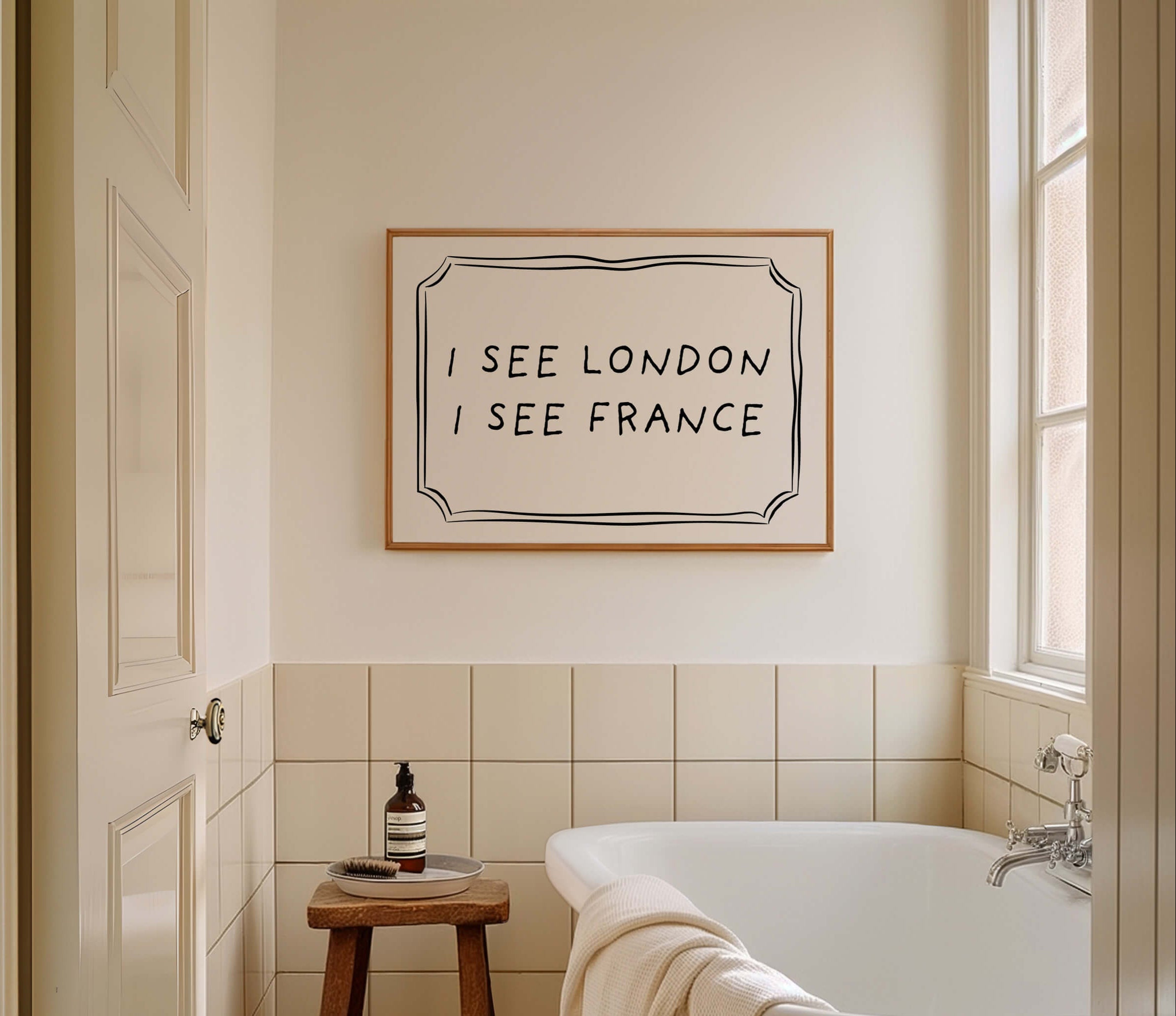 Bathroom with a bathtub, stool, and framed quote on the wall.