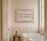Bathroom with a bathtub, stool, and framed quote on the wall.