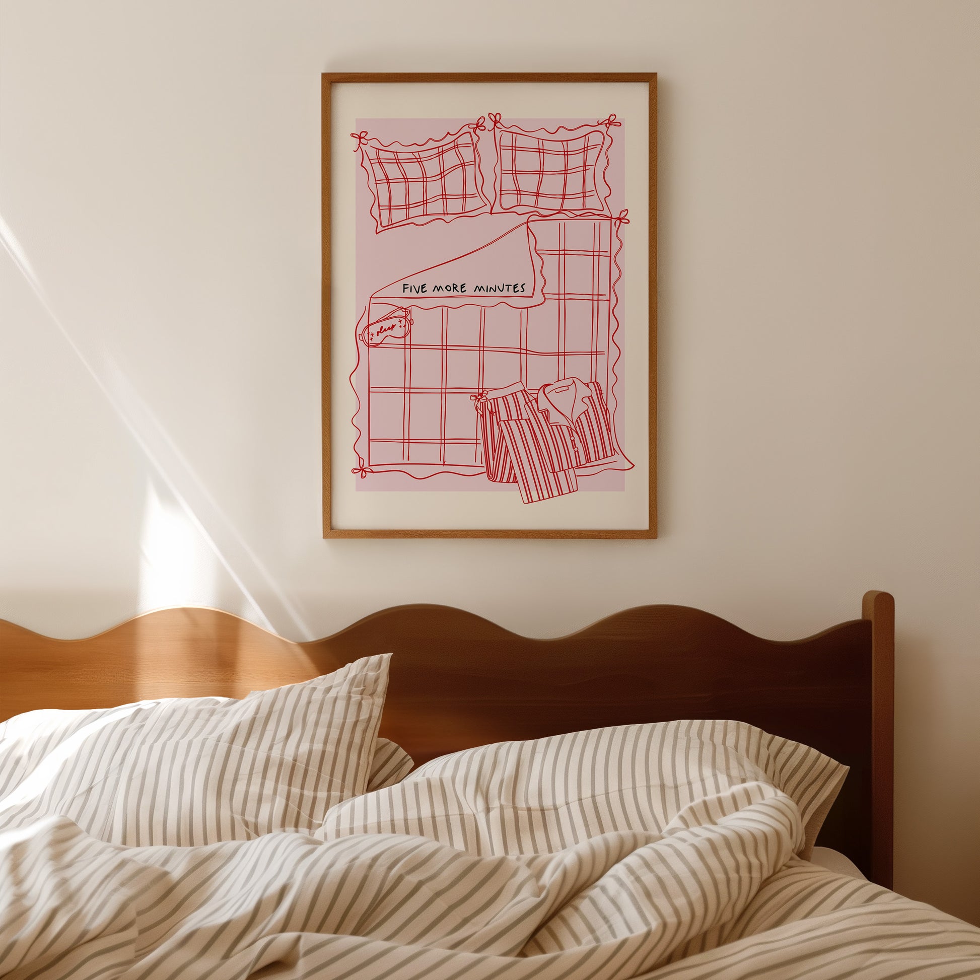 Framed artwork above a bed with striped bedding