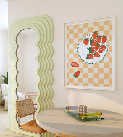 Modern interior with a wavy green room divider and a framed artwork of strawberries on a checkered background.
